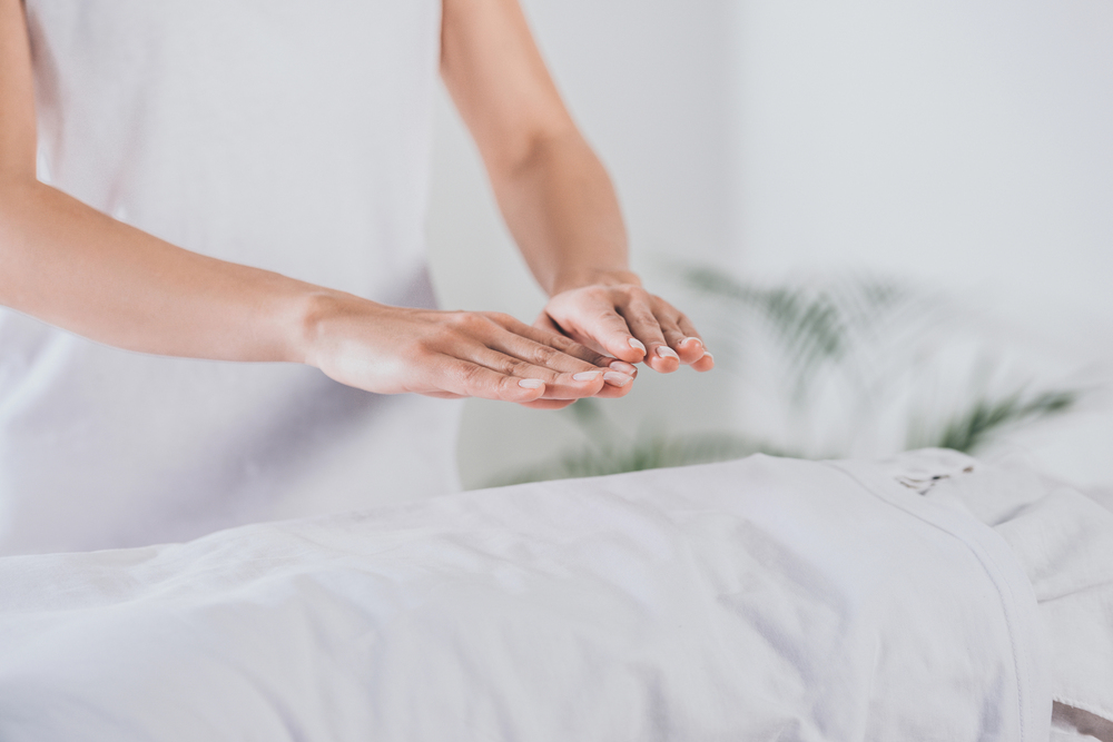 reiki practitioner with hands over body