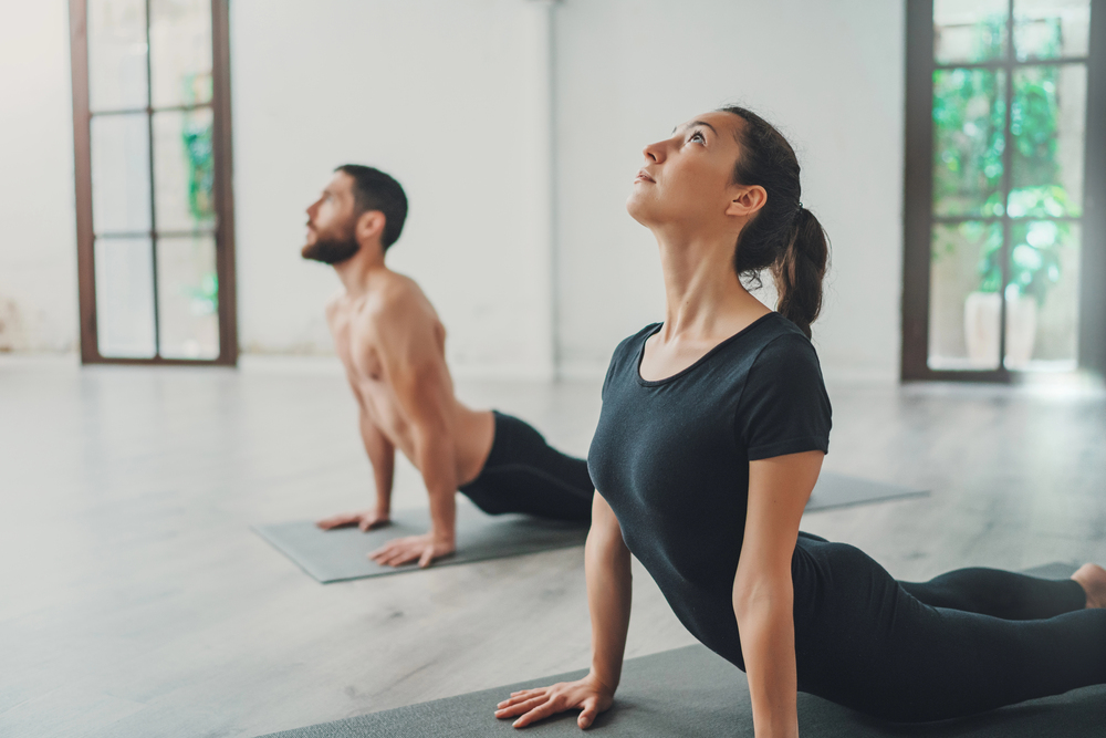 couple in cobra pose during yoga class